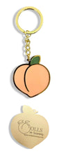 Load image into Gallery viewer, Super chic gold keychain of an enamel peach with Dolls In Training and www.dollsintraining.com laser engraved on the back.