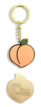 Load image into Gallery viewer, Super chic gold keychain of an enamel peach with Dolls In Training and www.dollsintraining.com laser engraved on the back.
